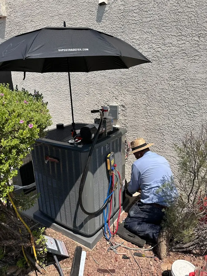HVAC technician performing outdoor AC maintenance in River Edge